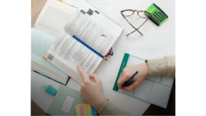 ספר לימוד פתוח עם יד רושמת באמצעות עיפרון